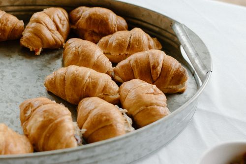 Free From above of baked croissants in tin tray prepared for dessert and placed on white table Stock Photo