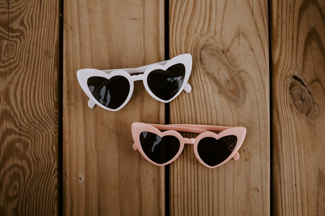 Free Stylish heart shaped sunglasses on wooden surface Stock Photo