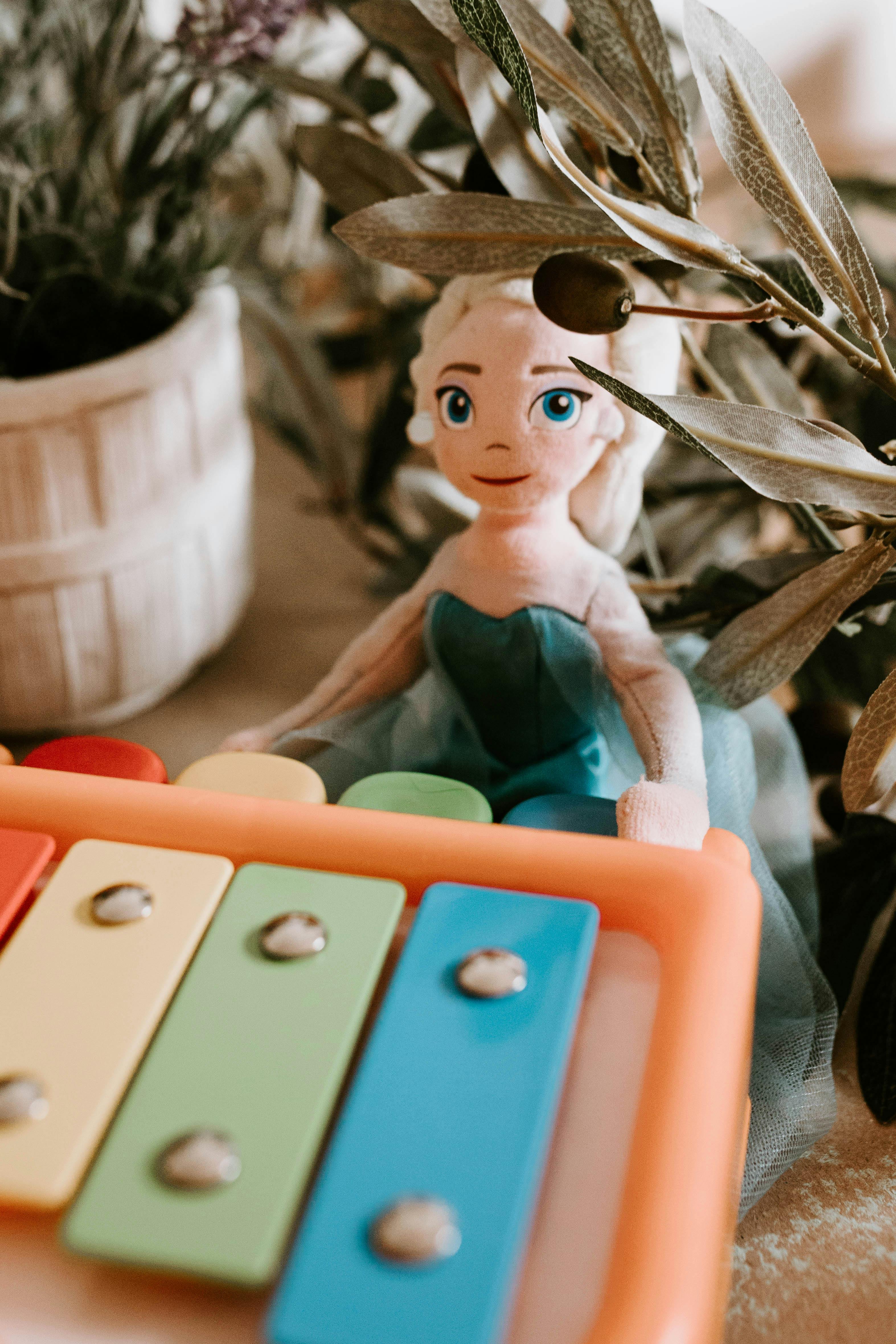 toy girl with musical instrument among plants