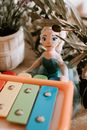 Toy girl with musical instrument among plants