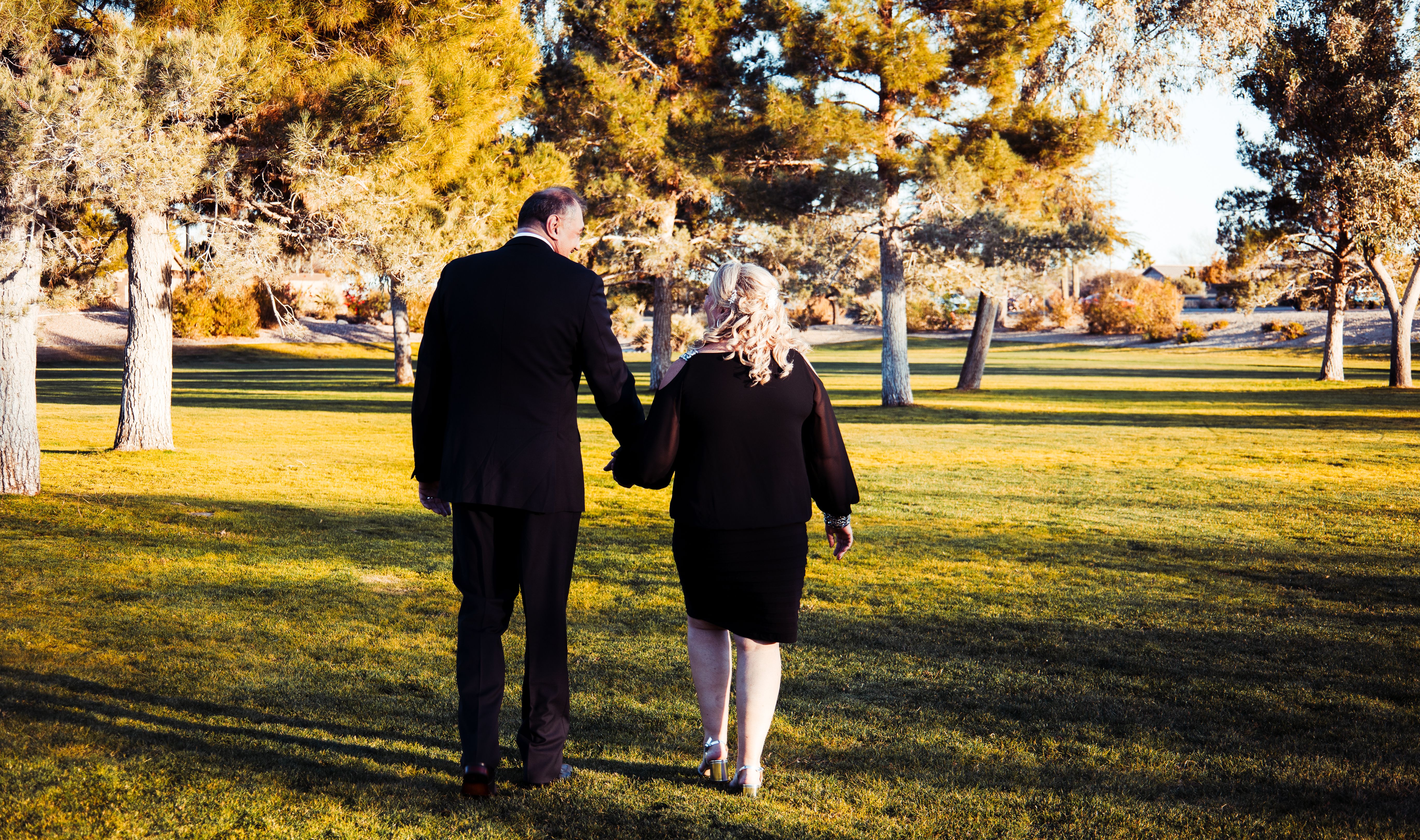 Man and Woman Walking on Green Grass Field while Holding Hands · Free ...