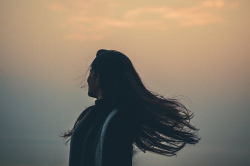 Anonymous woman standing on coast