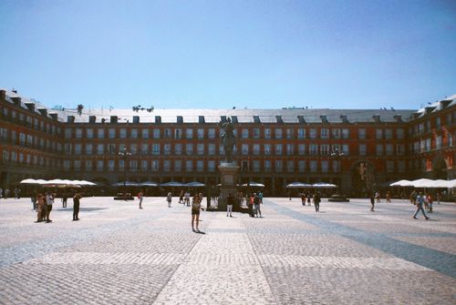 Free View of Plaza Mayor in Madrid with historical architecture, cobblestones, and tourists. Stock Photo