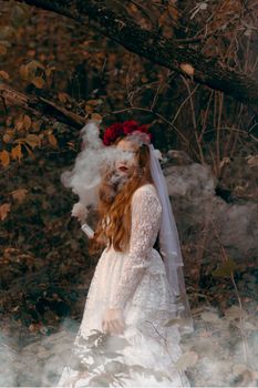 A mystical woman in a bridal dress surrounded by smoke in an enchanting forest setting.