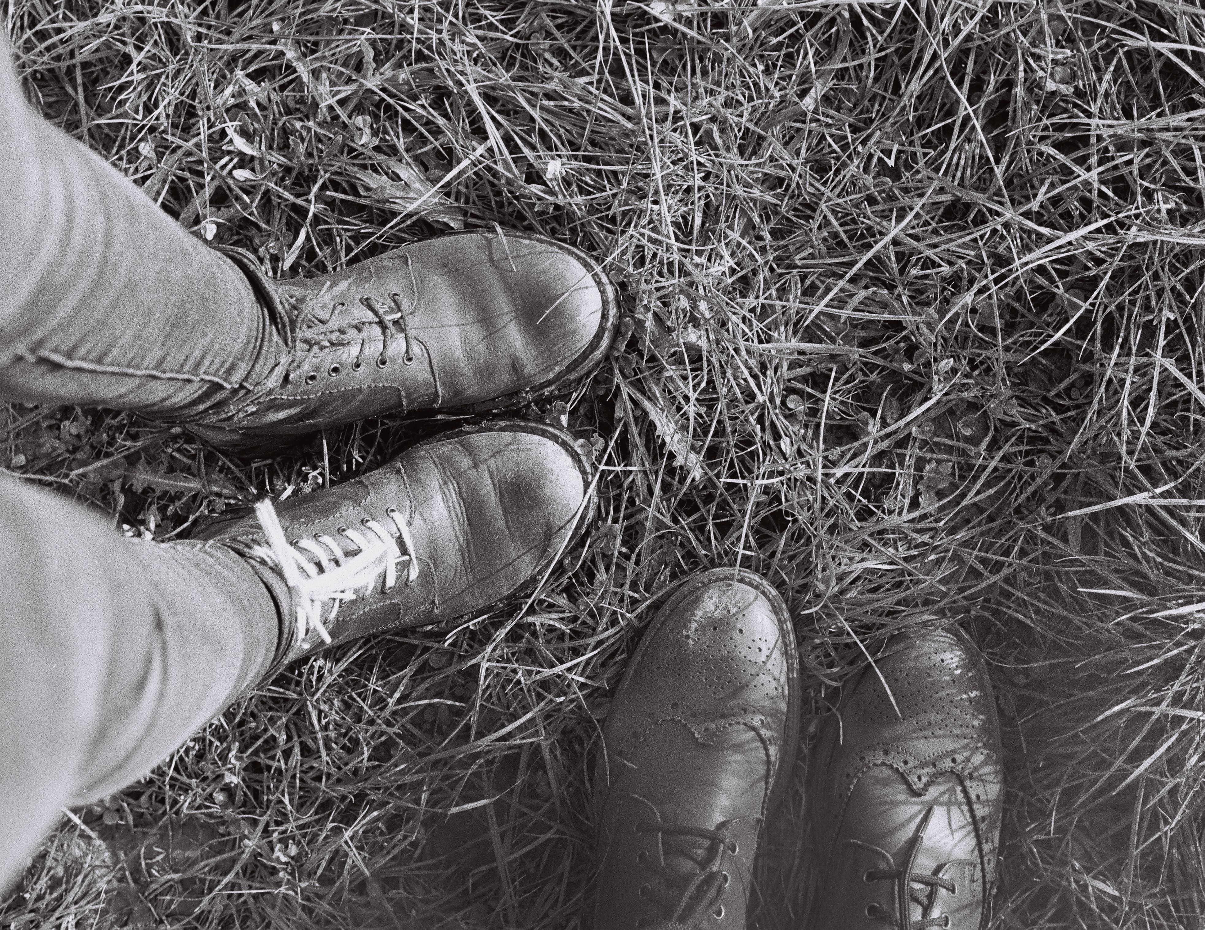 Grayscale Photo of Shoes on Dry Grass · Free Stock Photo