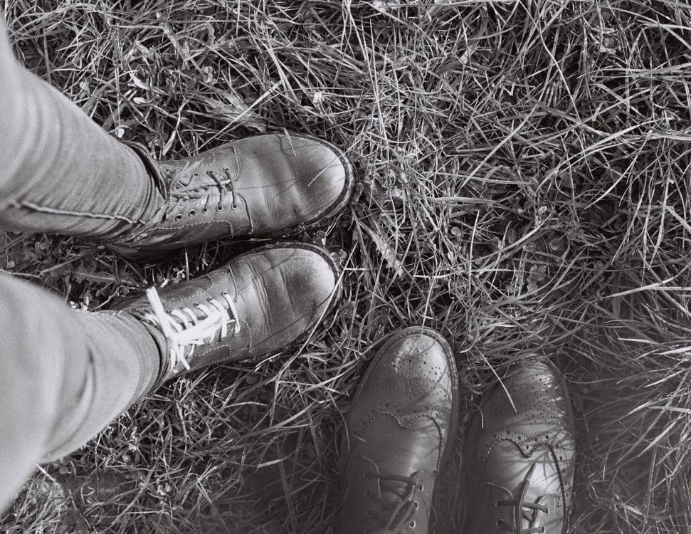 Grayscale Photo of Shoes on Dry Grass · Free Stock Photo