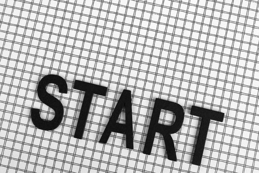 Black letters spelling 'START' on a white grid background, conceptual and minimalistic design.