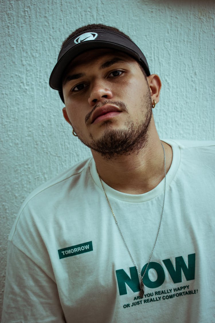 A Man In White Crew Neck Shirt Wearing Black Visor Cap