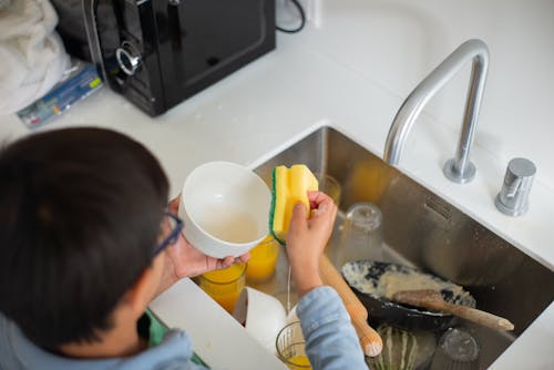 Nijvere Jongen Die De Afwas Schoonmaakt