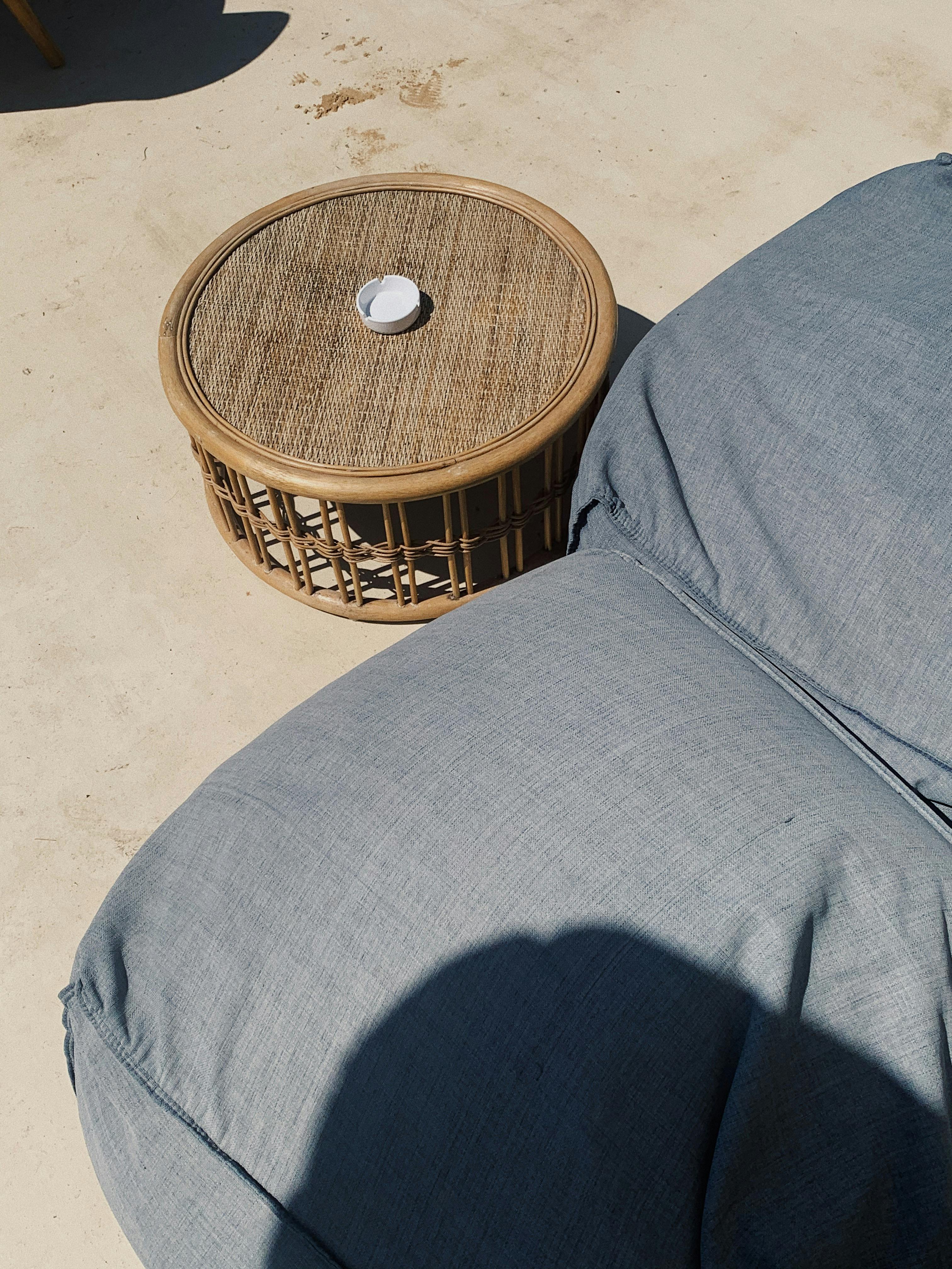 Minimalist outdoor scene with wicker table and cushions in Phú Quốc, Vietnam.