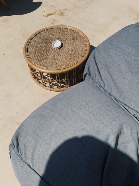 Minimalist outdoor scene with wicker table and cushions in Phú Quốc, Vietnam.