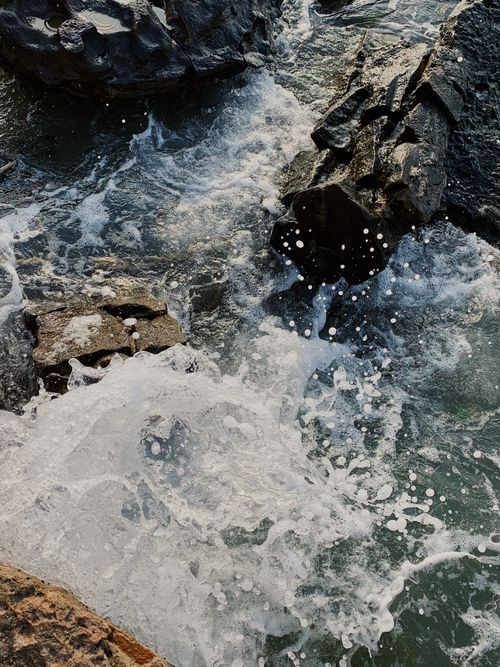 Free Capture of ocean waves splashing against rugged rocks in Phú Quốc, Vietnam, showcasing nature's power. Stock Photo