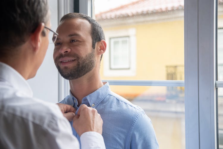 Couple Of Men Looking At Themselves By The Window 