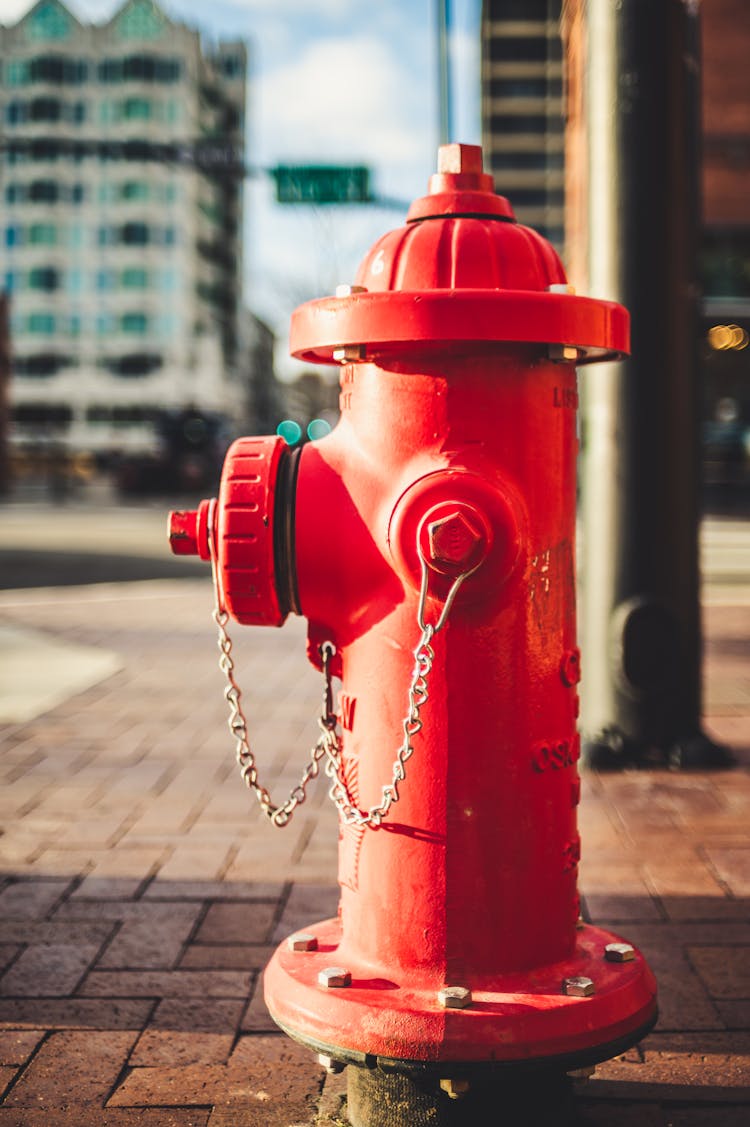 Red Fire Hydrant On City Street In Sunlight