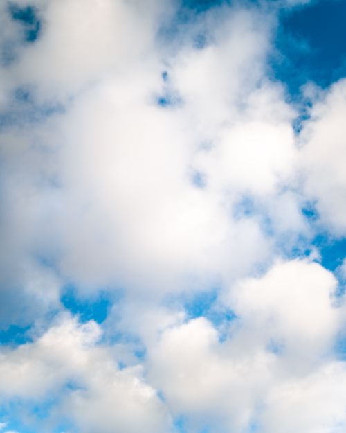 Free From below of white fluffy cumulus clouds floating in blue sky in sunlight Stock Photo