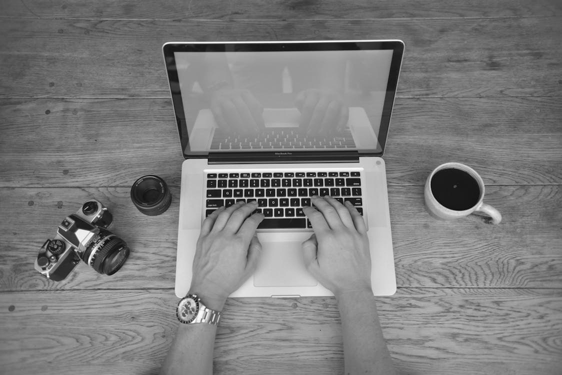 Free Gray Scale Photography of a Person Using Laptop Stock Photo