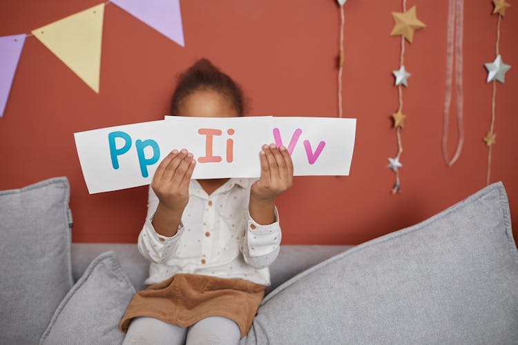 A Girl Holding Alphabet Cards