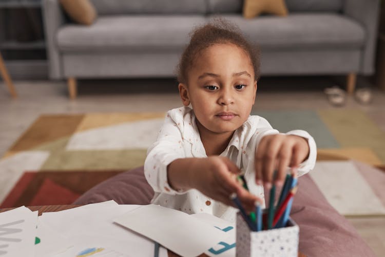 Child Holding A Bunch Of Pencils