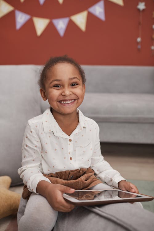 Smiling Little Girl Holding a Tablet