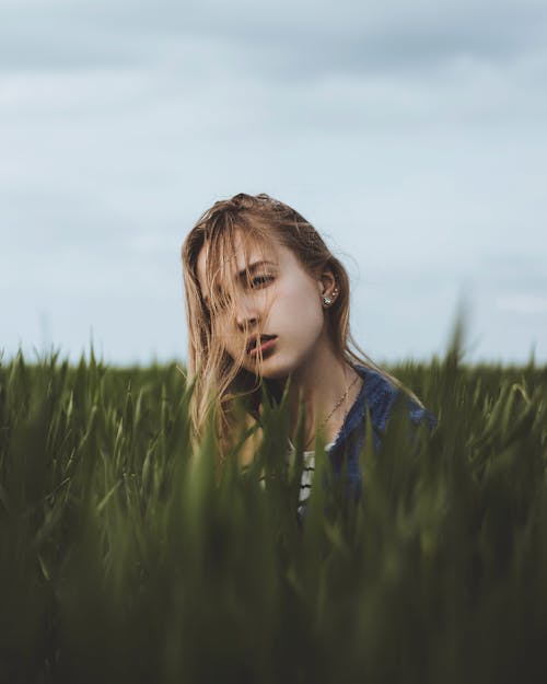 Tranquil woman sitting in tall grass