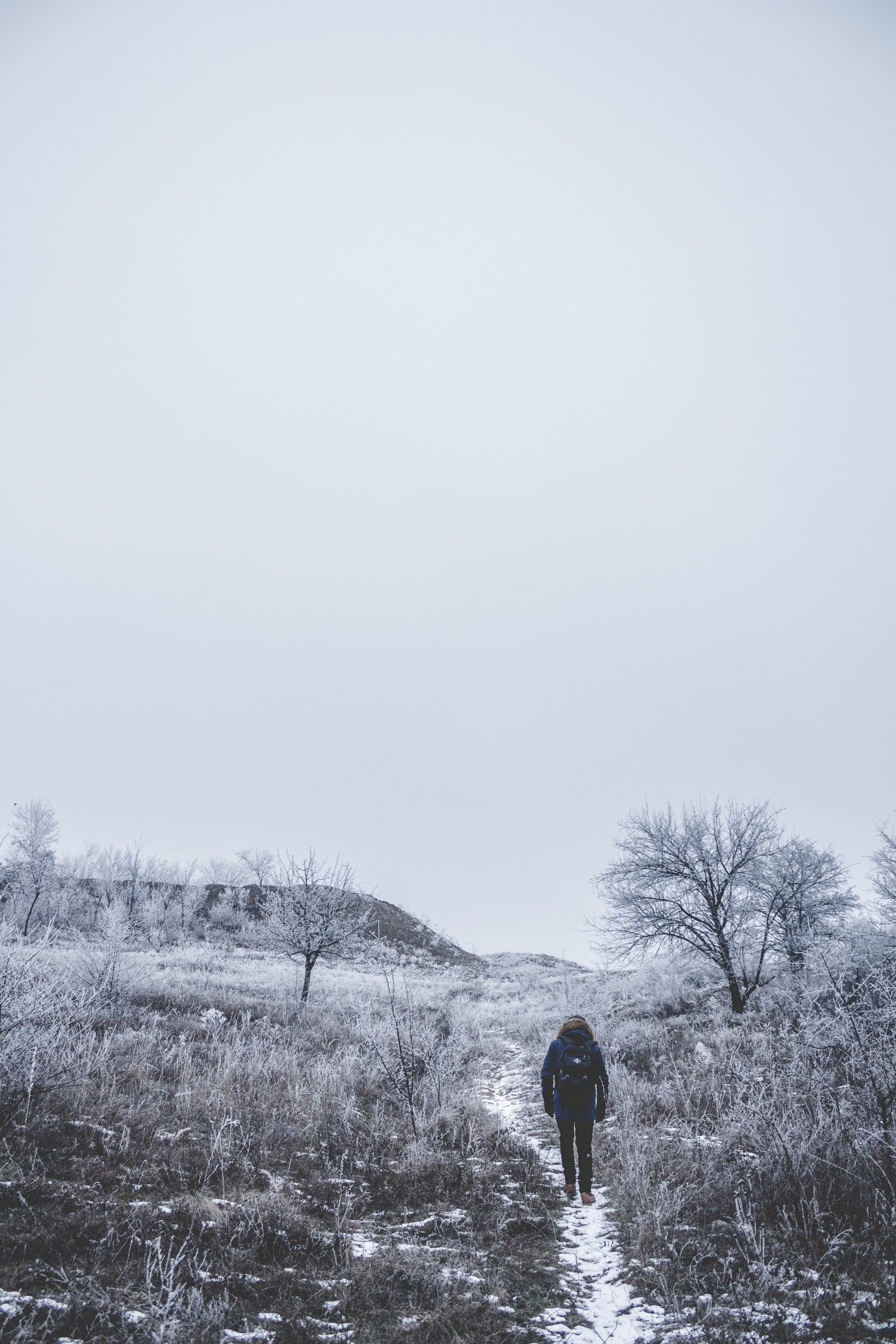 Faceless person walking on snowy field · Free Stock Photo