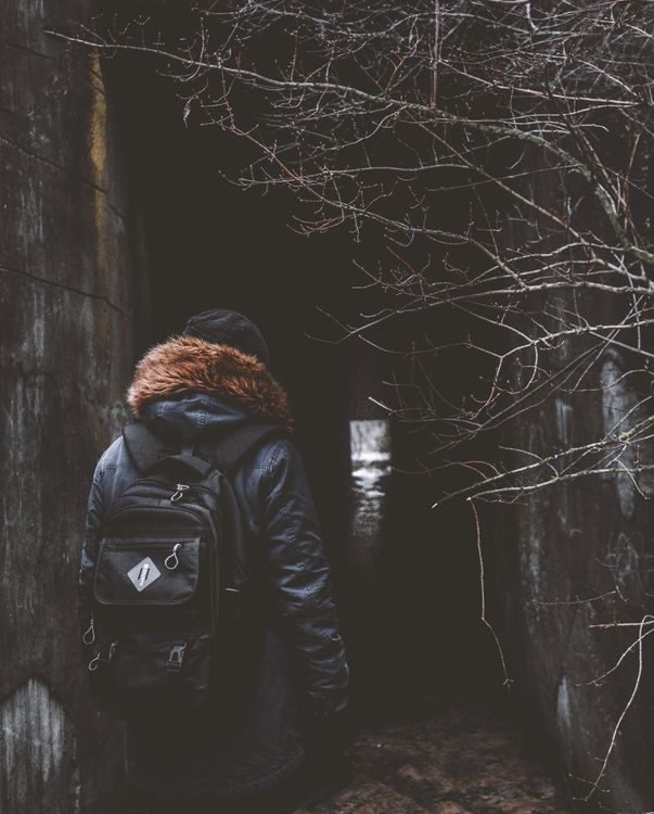 Anonymous person standing near dark tunnel · Free Stock Photo
