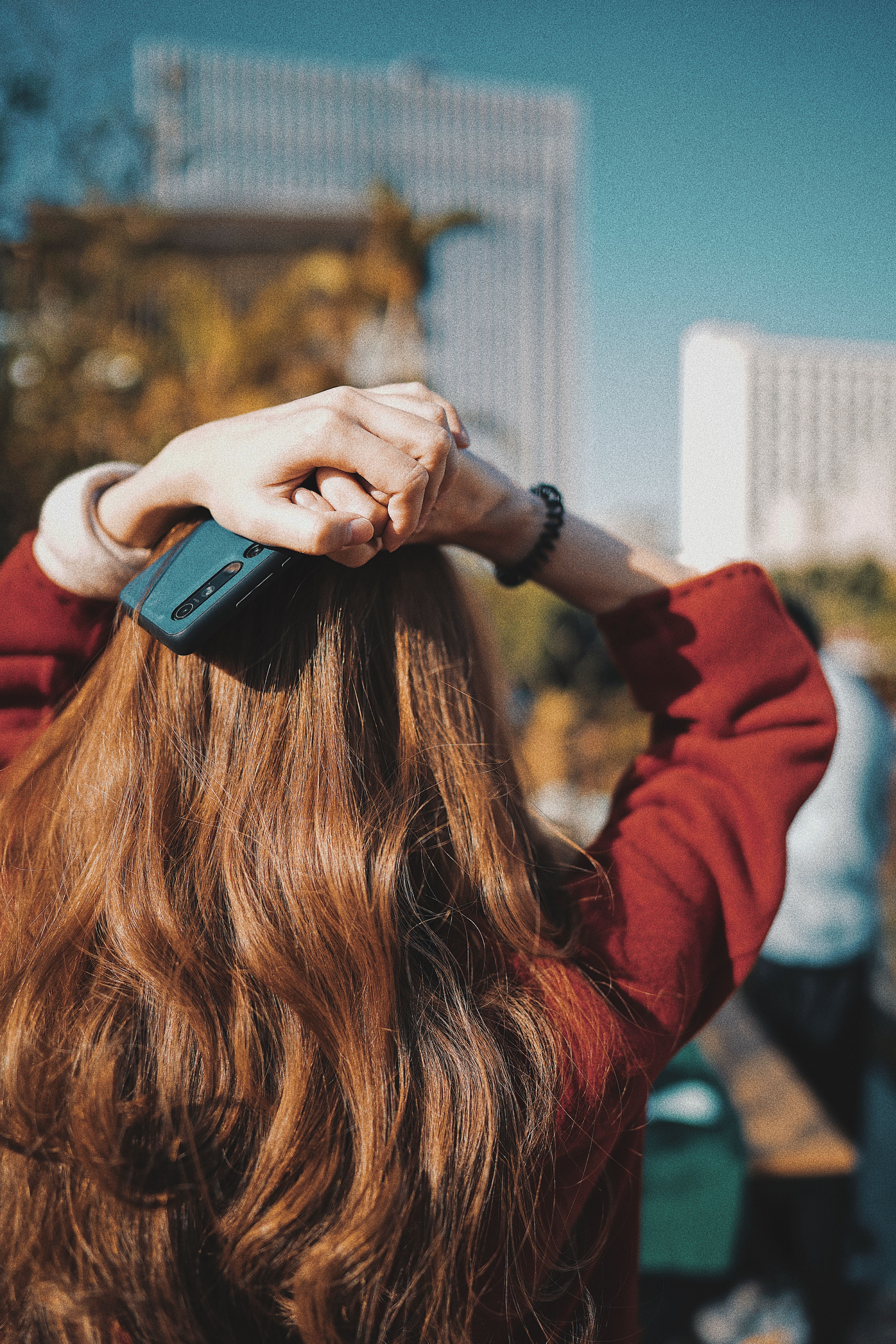 A Woman in Red Jacket Holding a Smartphone on Her Hear · Free Stock Photo