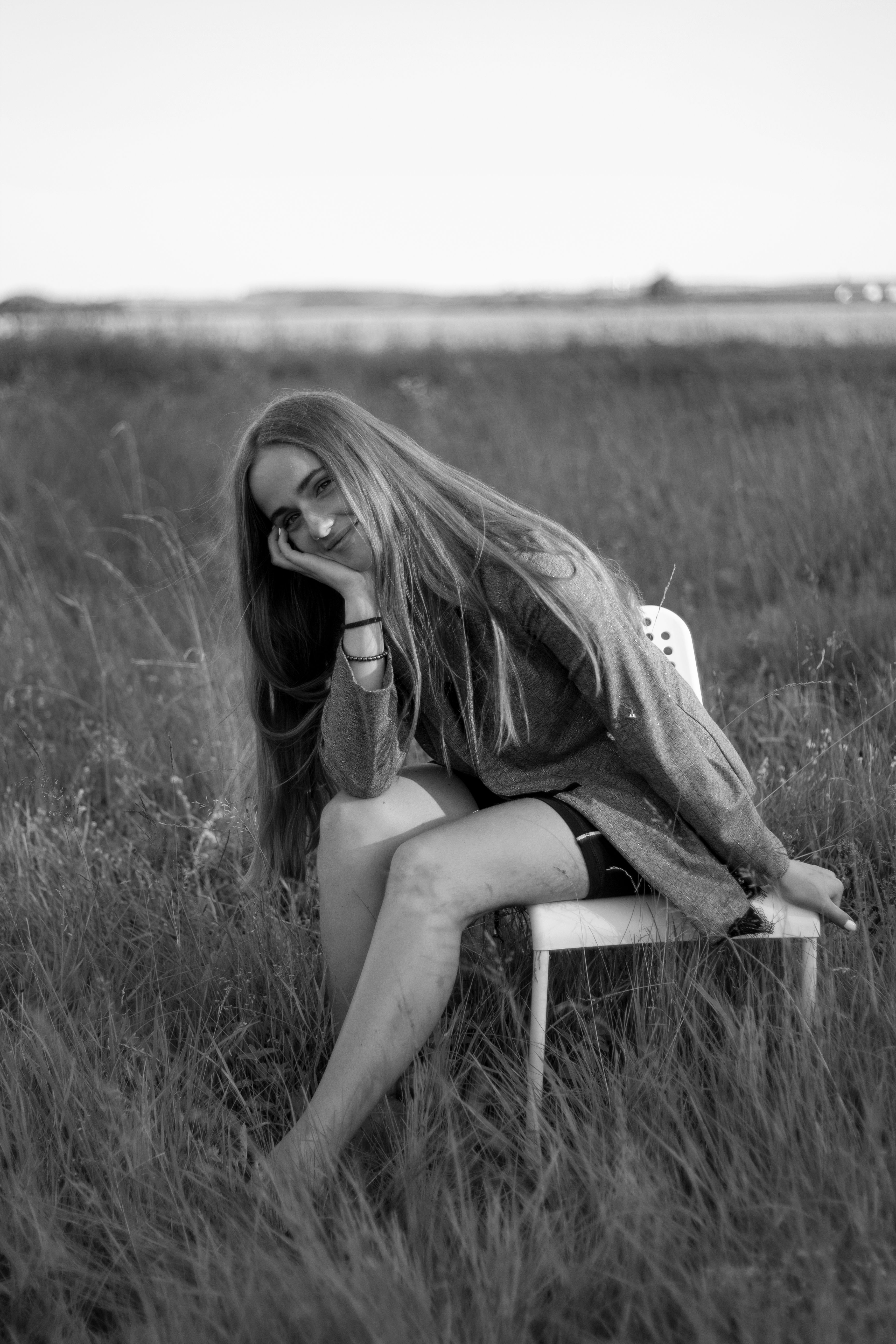 Grayscale Photo of Woman Sitting on a Chair while on a Grass Field ...