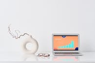 Laptop beside a Ceramic Vase