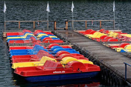Free Vibrant paddle boats docked at the scenic Eibsee, ready for aquatic adventures. Stock Photo