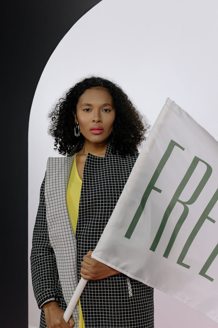 A Woman In Checkered Coat Holding A Flag