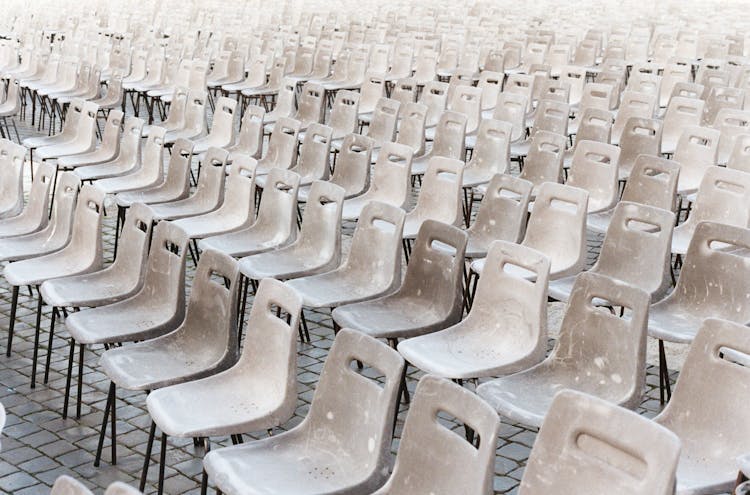 White Stained Plastic Chairs On Brick Floor