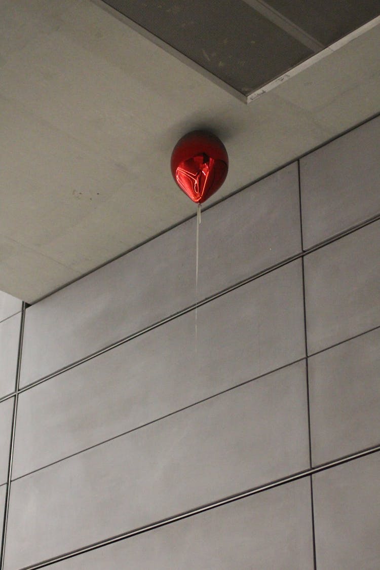 Red Shiny Balloon With White String  On Ceiling 