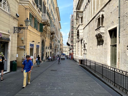 People Walking on Sidewalk Near Shops