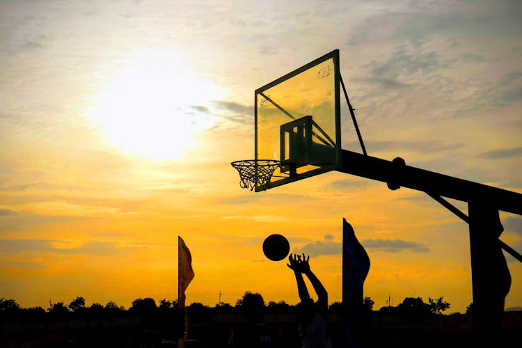 Silhouette Of Hands Catching Ball During Sunset