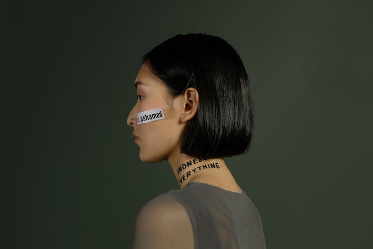 Young Woman Standing With Slogan Quotes On Her Face And Neck