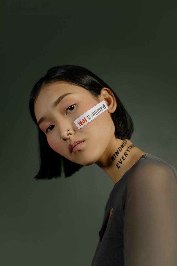 Young Woman Standing With Slogan Quotes On Her Face And Neck