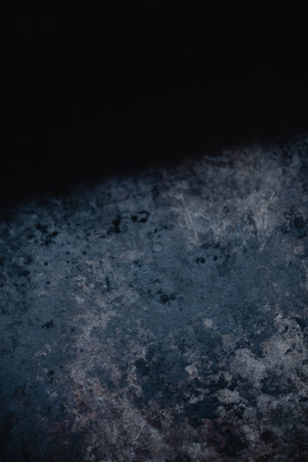 A dark weathered metal surface. Photo by Eva Bronzini on Pexels