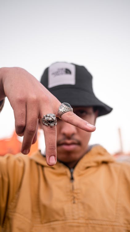 Man Wearing Orange Jacket Wearing Silver Rings