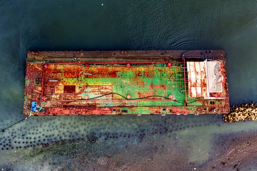 Free Discover the textured aerial view of an abandoned rusty ship moored off Jakarta's coast. Stock Photo