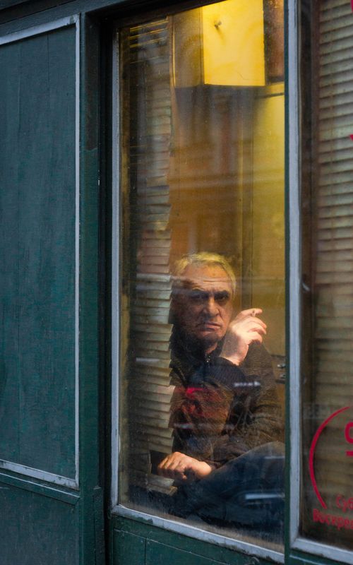 Free Elderly man seen through a window with reflections in Saint Petersburg, Russia. Stock Photo