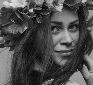 Elegant black and white portrait of a woman wearing a floral wreath symbolizing natural beauty.