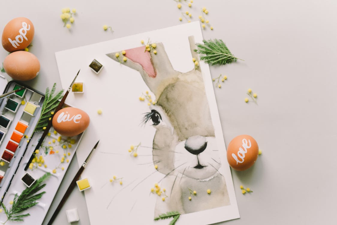 Free Painting Of A Bunny Beside Brown Painted Eggs On Table Stock Photo
