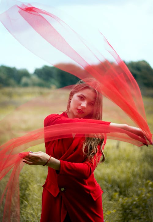 Portrait of a Woman Posing with a Red Sheer Fabric