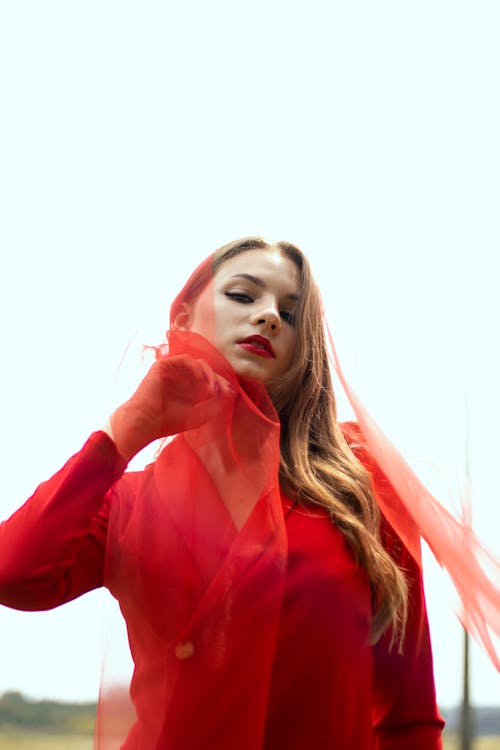 Low-Angle Shot of a Woman with a Red Sheer Fabric