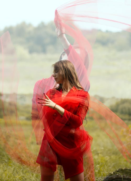 Woman in a Red Coat Posing with a Sheer Fabric