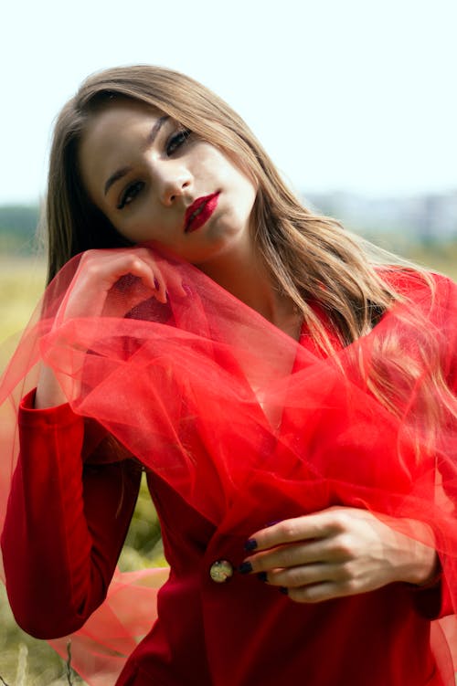 Woman in a Red Top Posing with a Sheer Fabric