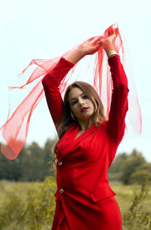 A Woman in Red Clothes Posing While in the Farm