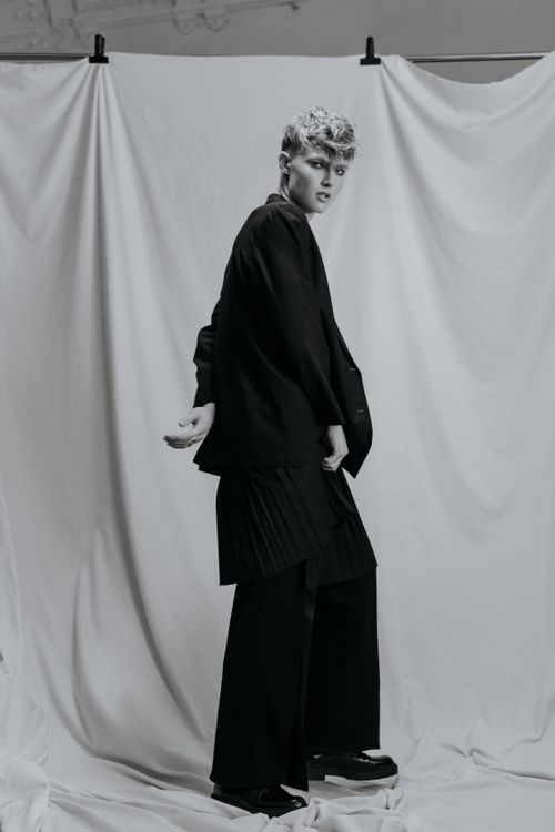 Free Elegant black and white portrait of a fashionable man posing in a studio setting. Stock Photo