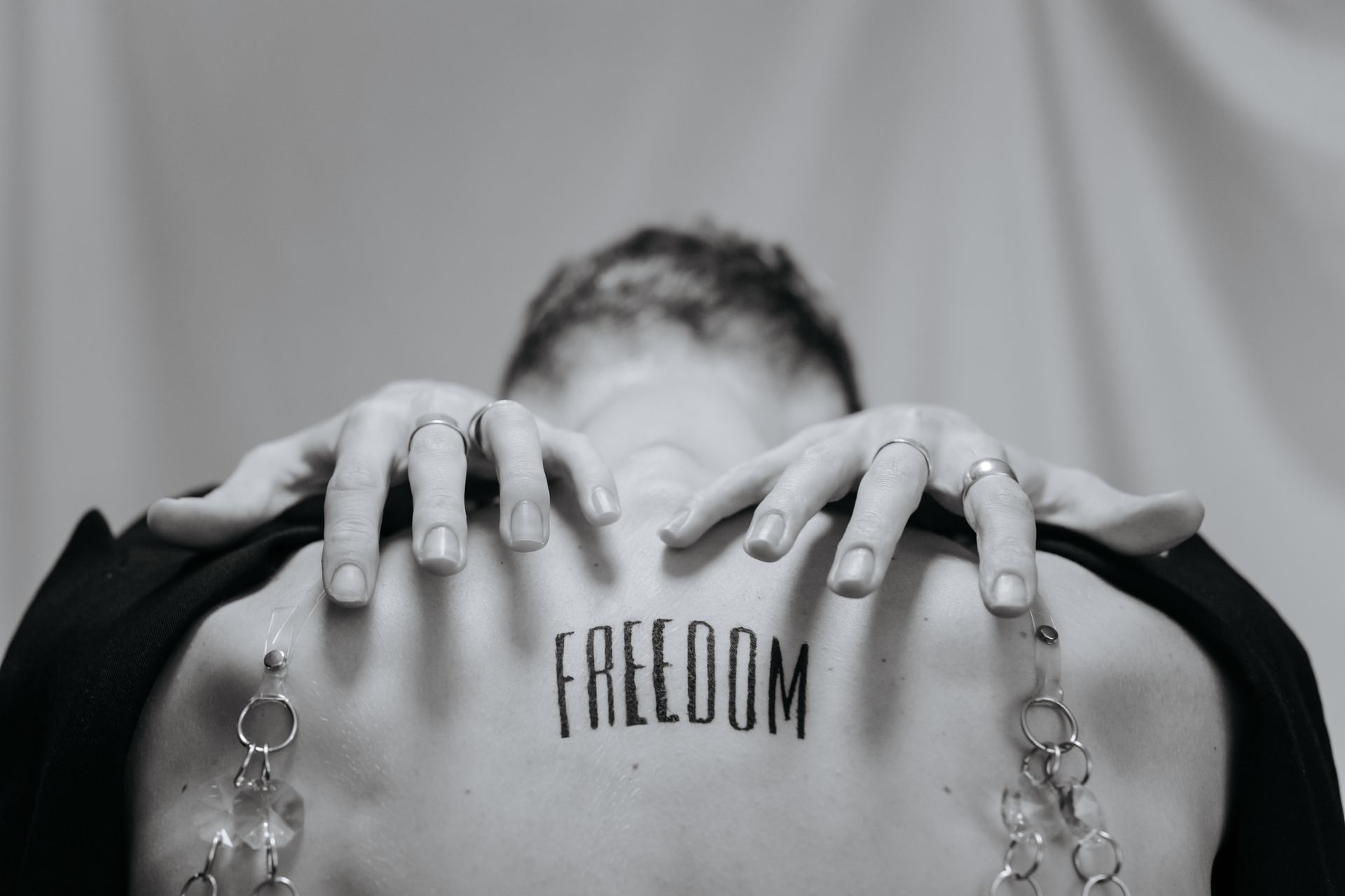 Grayscale Photograph of a Freedom Tattoo on a Person's Back
